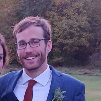 man with short hair wearing glasses and a suit